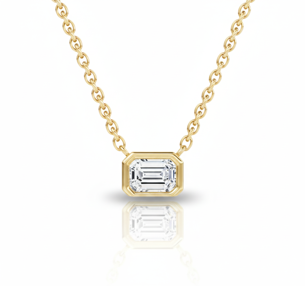 Gold necklace with a diamond pendant on a white background