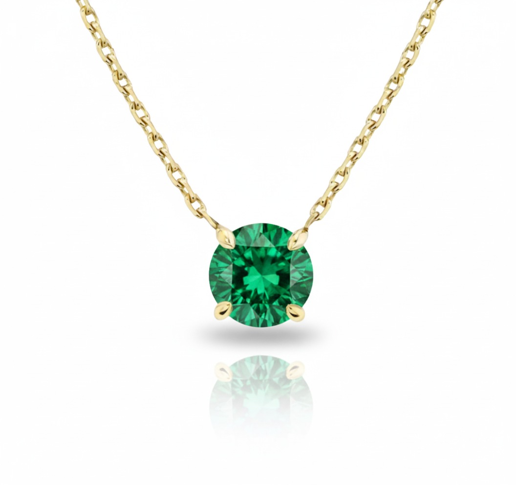 Gold necklace with a green gemstone on a white background