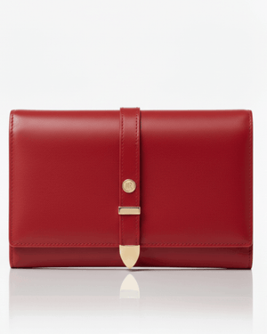 Red leather clutch bag with gold accents on a white background