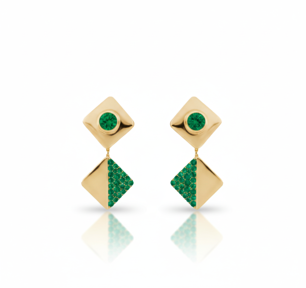 Gold earrings with green gemstones on a white background