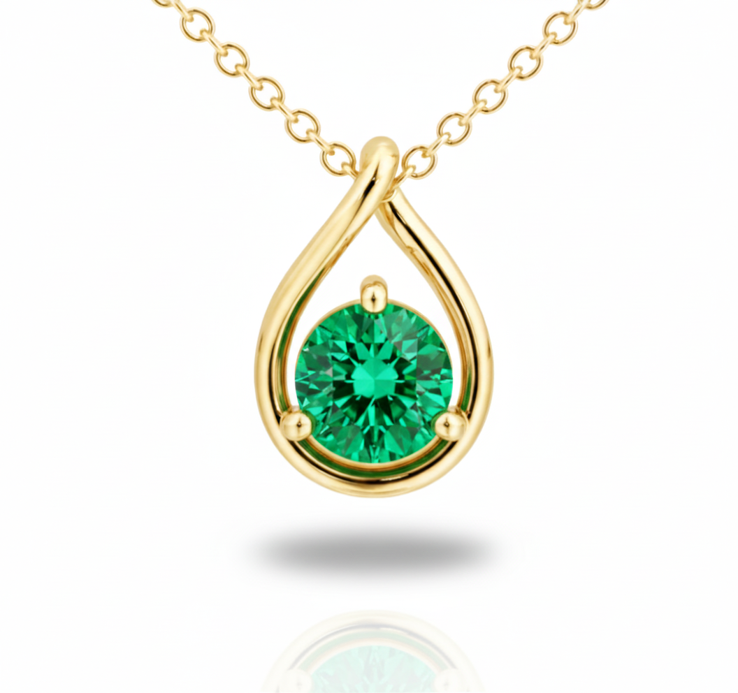 Gold necklace with a green gemstone pendant on a white background