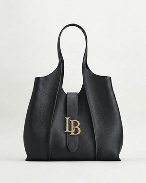 Black handbag with gold logo on a light gray background