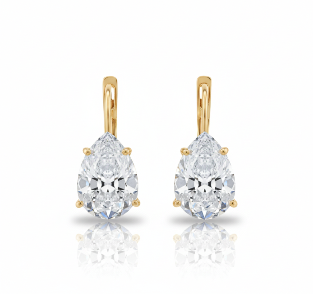 Pair of gold teardrop-shaped diamond earrings on a white background