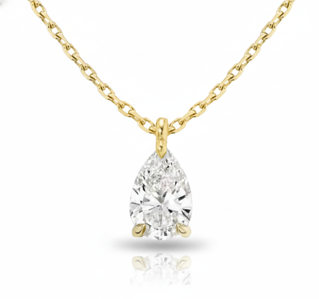 Gold necklace with a pear-shaped diamond pendant on a white background