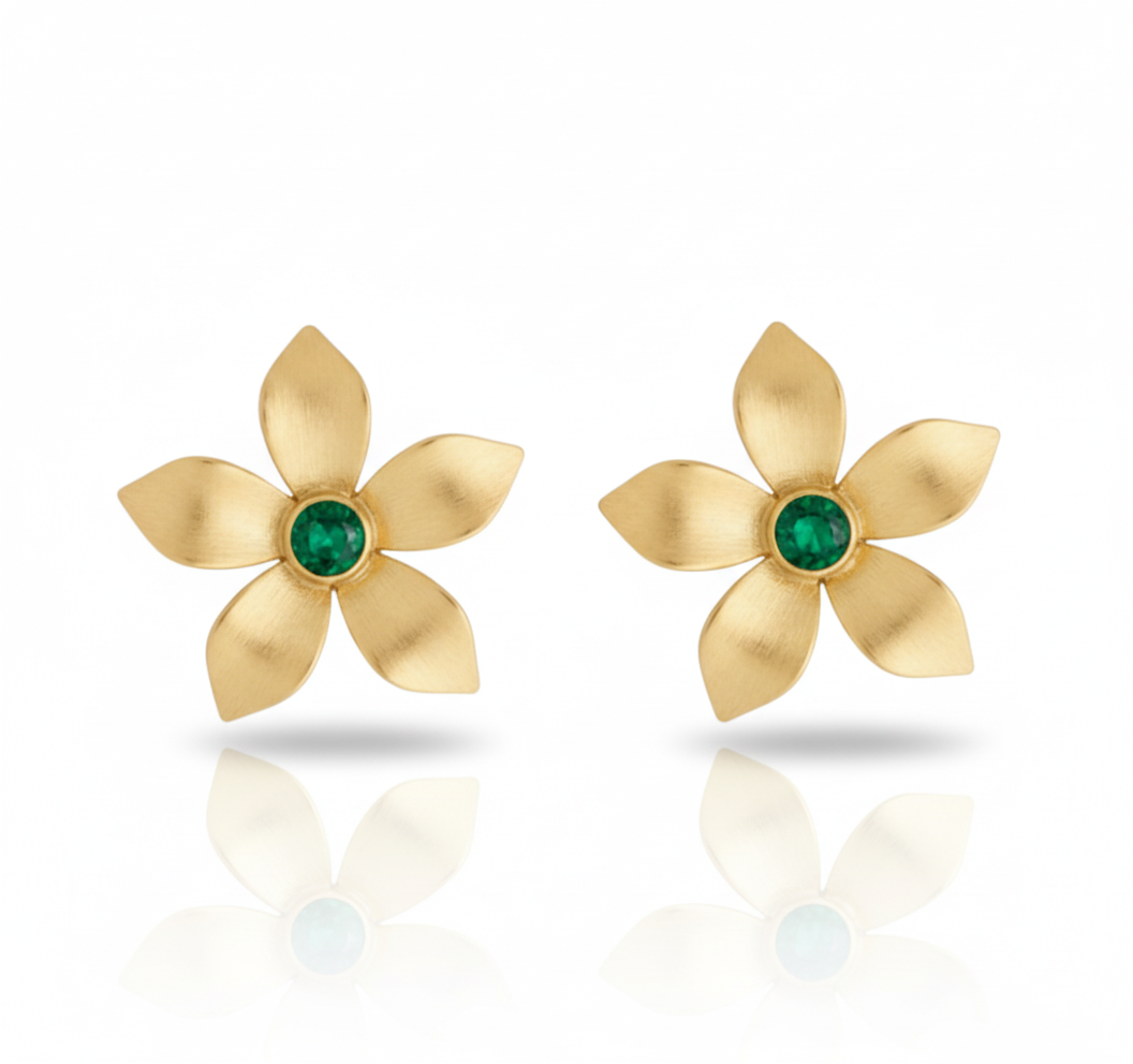 Gold flower-shaped earrings with green gemstones on a white background