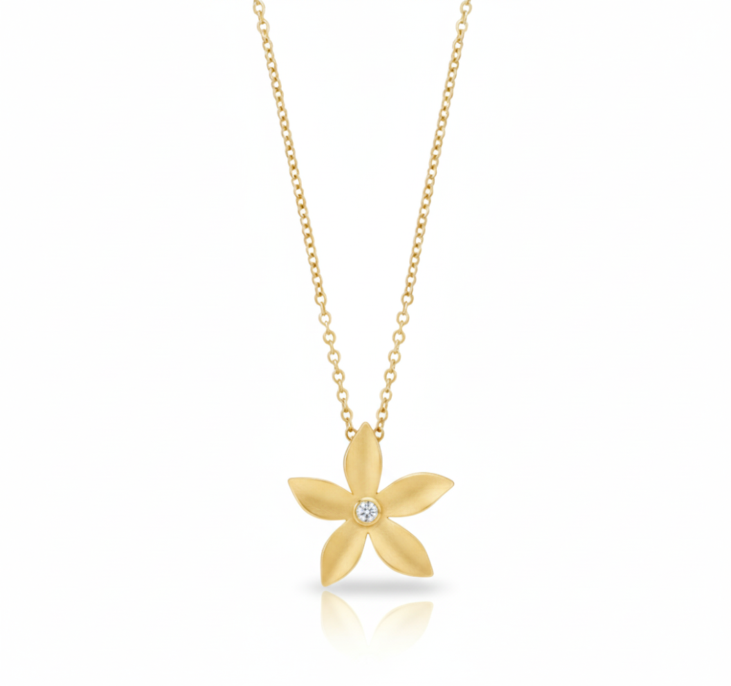 Gold flower-shaped necklace with a diamond on a white background