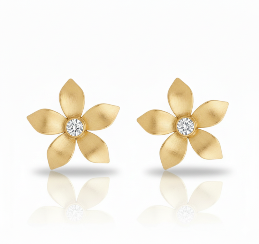 Gold flower-shaped earrings with diamond centers on a white background