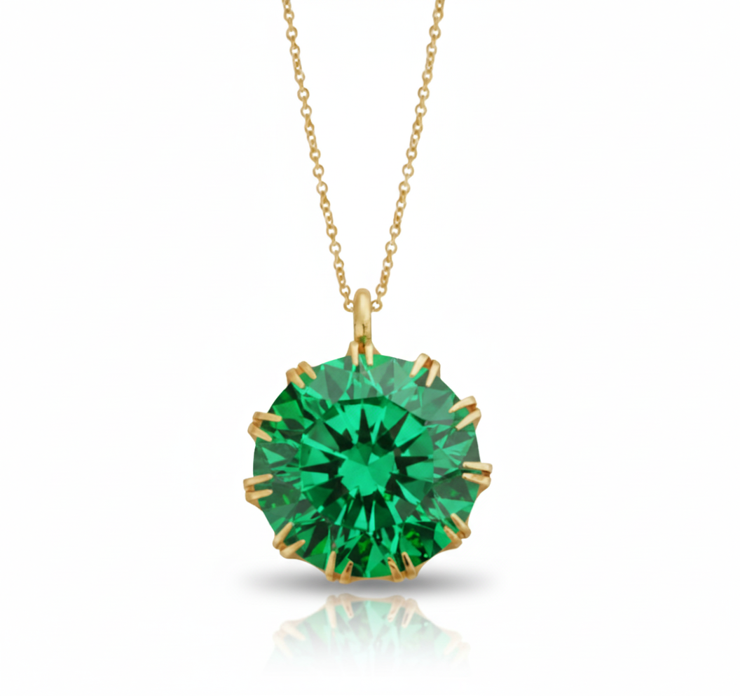 Gold necklace with a green gemstone pendant on a white background