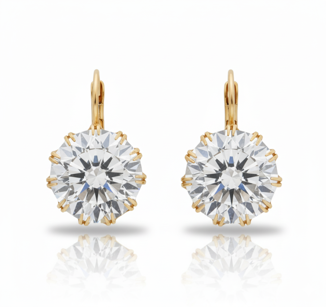 Gold earrings with large clear gemstones on a white background