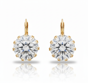 Gold earrings with large clear gemstones on a white background