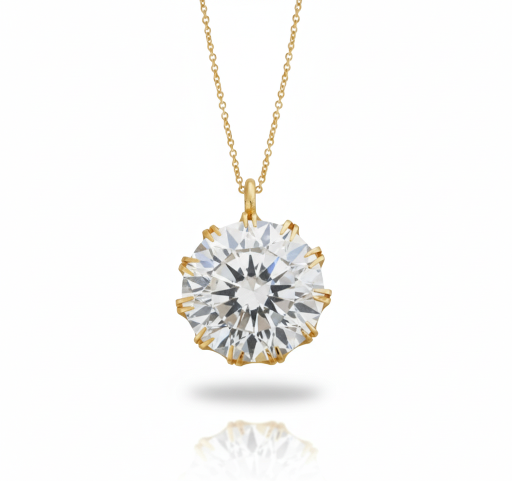 Gold necklace with a large diamond pendant on a white background