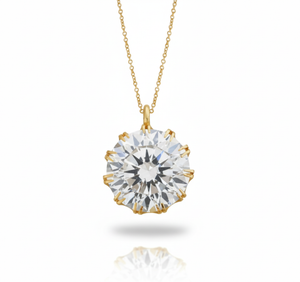 Gold necklace with a large diamond pendant on a white background