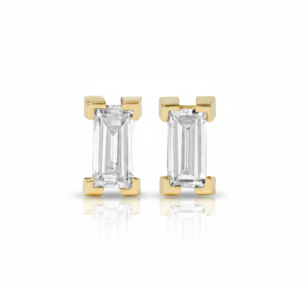 Gold earrings with emerald-cut gemstones on a white background
