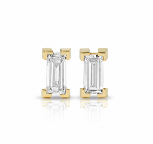 Gold earrings with emerald-cut gemstones on a white background
