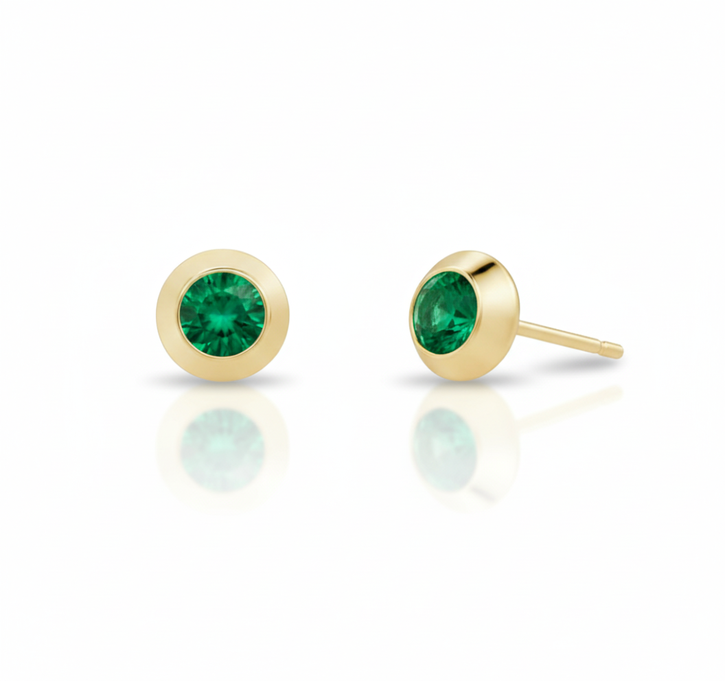 Gold stud earrings with green gemstones on a white background