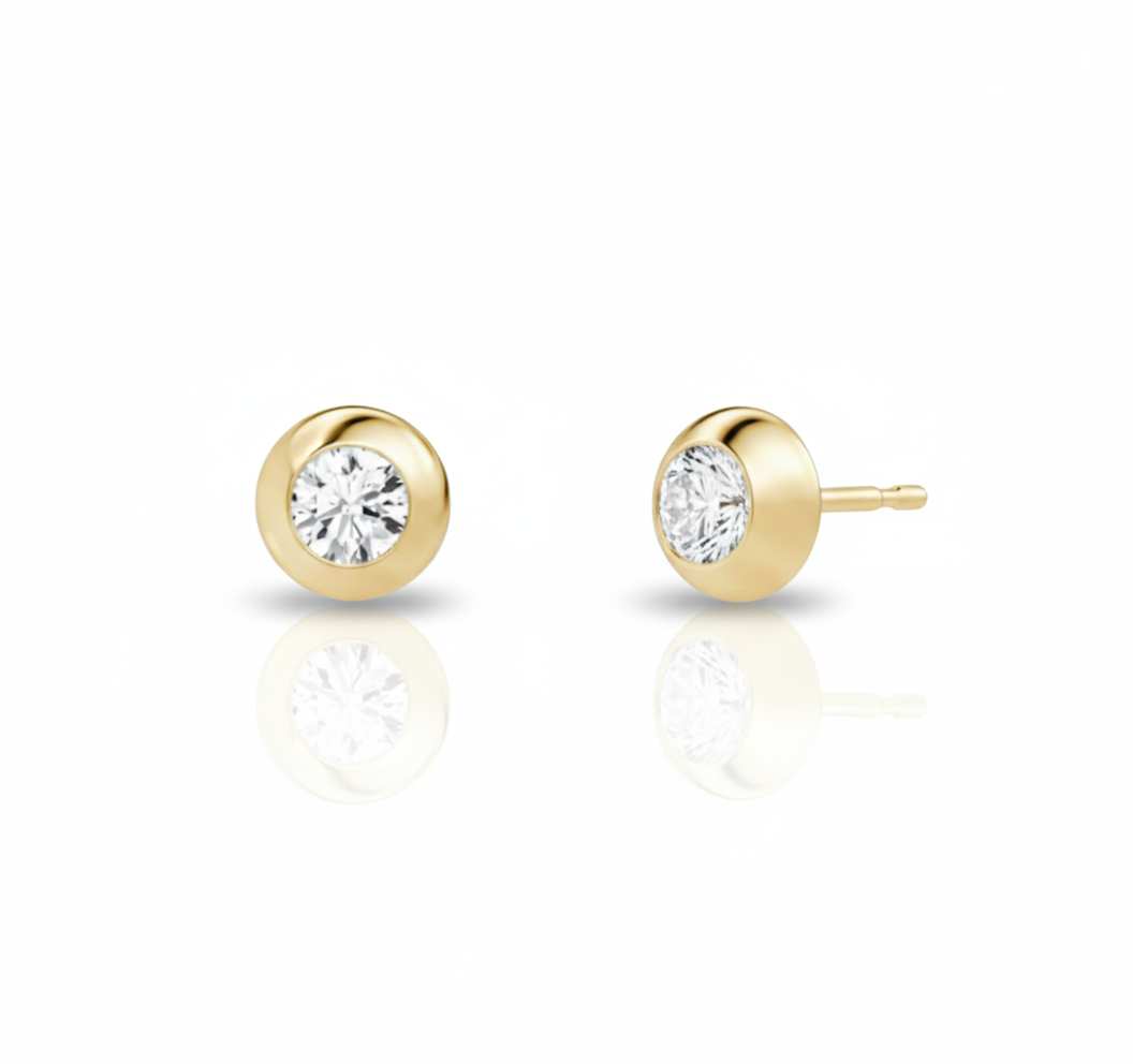 Gold stud earrings with clear gemstones on a white background