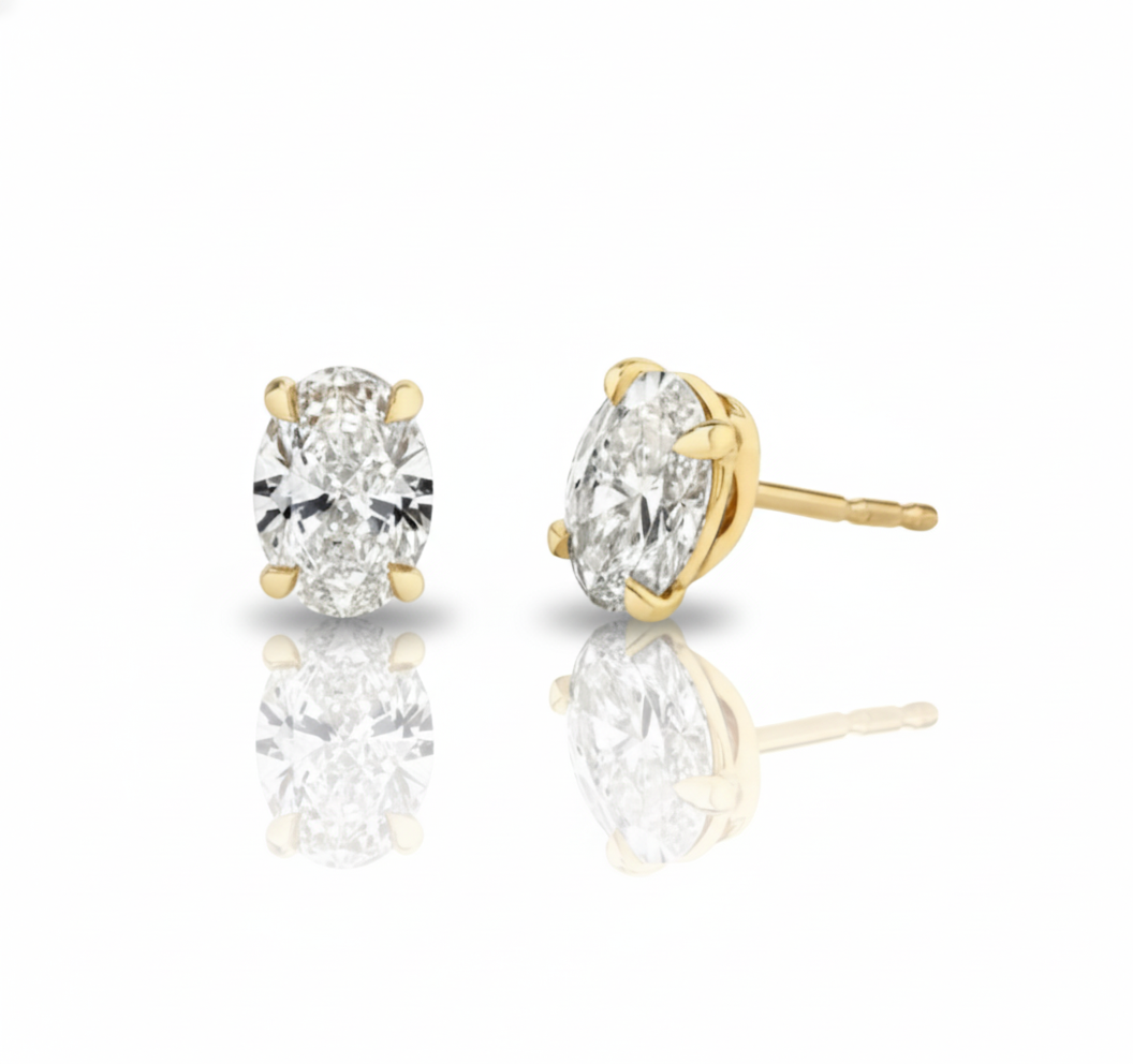 Gold earrings with clear gemstones on a white background