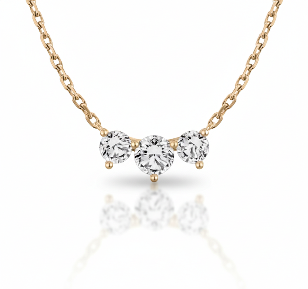 Rose gold necklace with three diamond-like stones on a white background