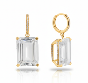 Gold earrings with emerald-cut clear gemstones on a white background