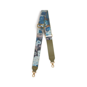 Floral patterned bag strap with gold hardware on a white background