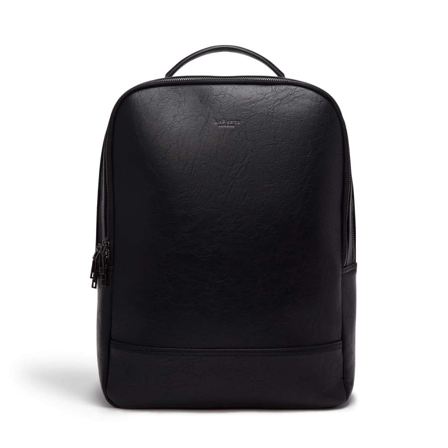 Acacia Black Backpack. Vegan and Sustainable. A laptop-sized rectangular black vegan leather backpack with rounded corners. It has two compartments with black zips and a smooth front exterior.